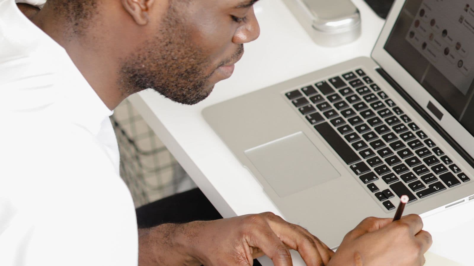 Writing notes beside a laptop, the output an AI call summary prompt is meant to replace
